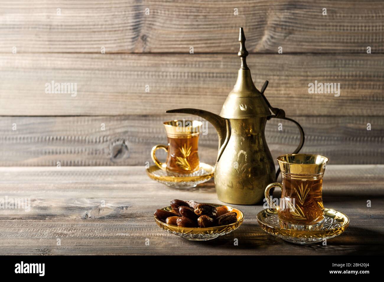 Teekanne und Gläser goldene orientalische Dekoration auf Holzhintergrund Stockfoto