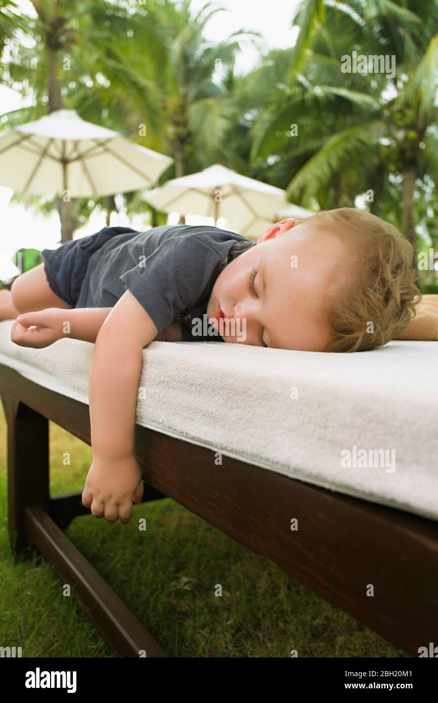 Kleiner Junge schläft auf der Sonnenliege, Koh Samui, Thailand Stockfoto