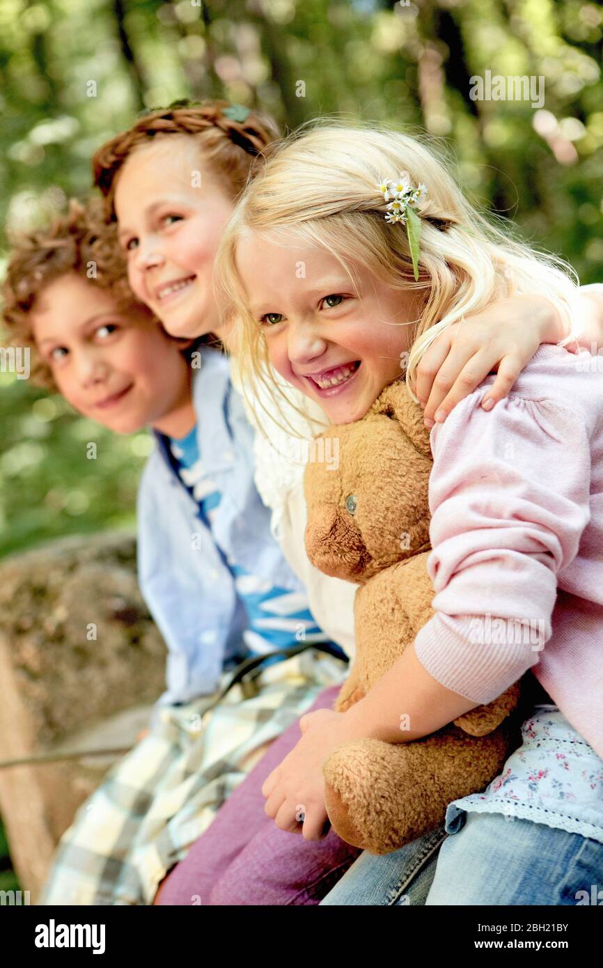 Glückliche Kinder umarmen im Wald Stockfoto