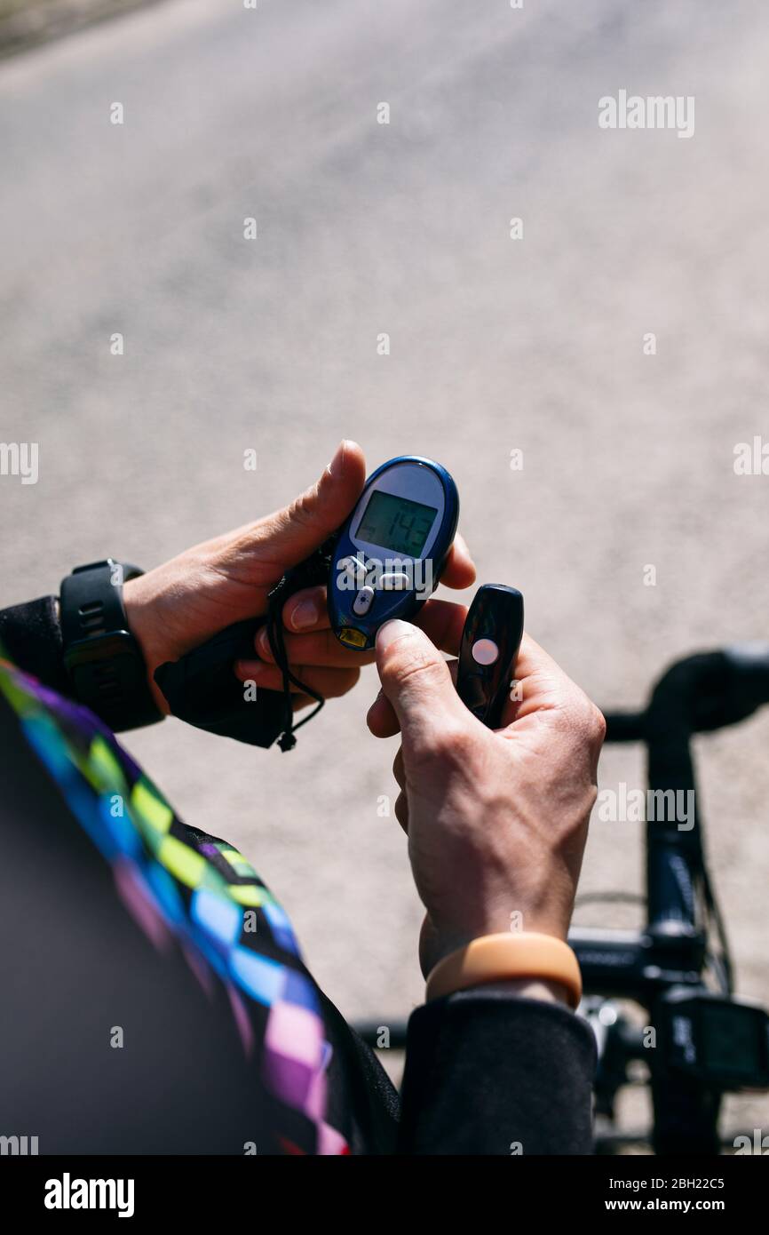 Nahaufnahme eines diabetischen Radfahrers, der seinen Zuckerspiegel überprüft Stockfoto