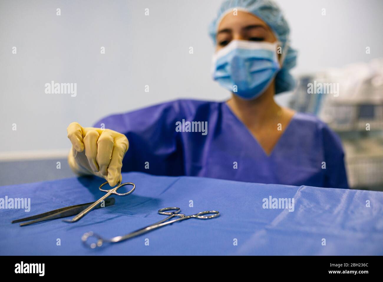 Krankenschwester im Operationssaal, die ein chirurgisches Instrument nimmt Stockfoto