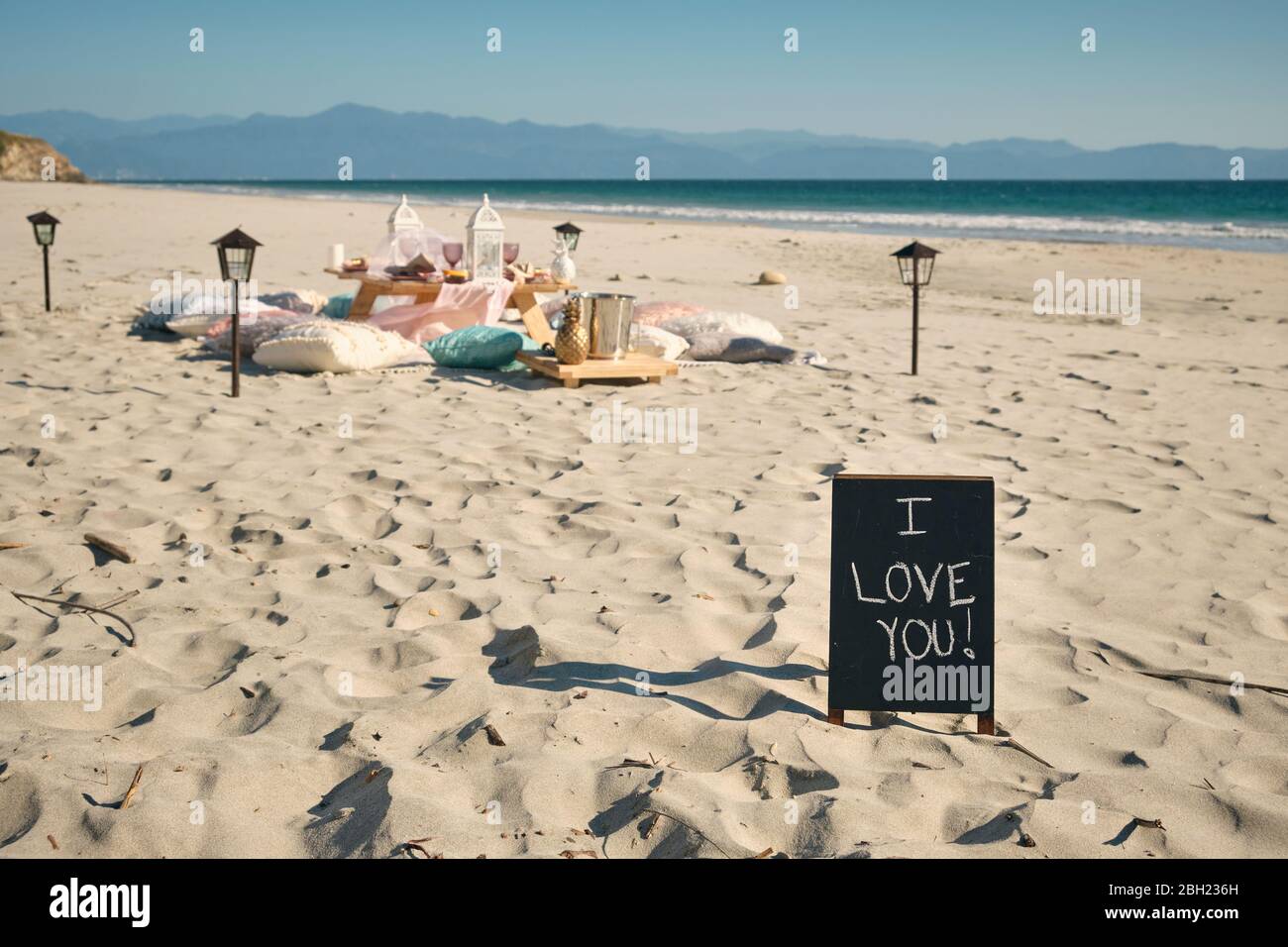 Ich LIEBE ES, DASS SIE an sonnigen Tagen, Nayarit, Mexiko, auf einem Schild neben dem Esstisch am Strand gegen den klaren blauen Himmel unterschreiben Stockfoto