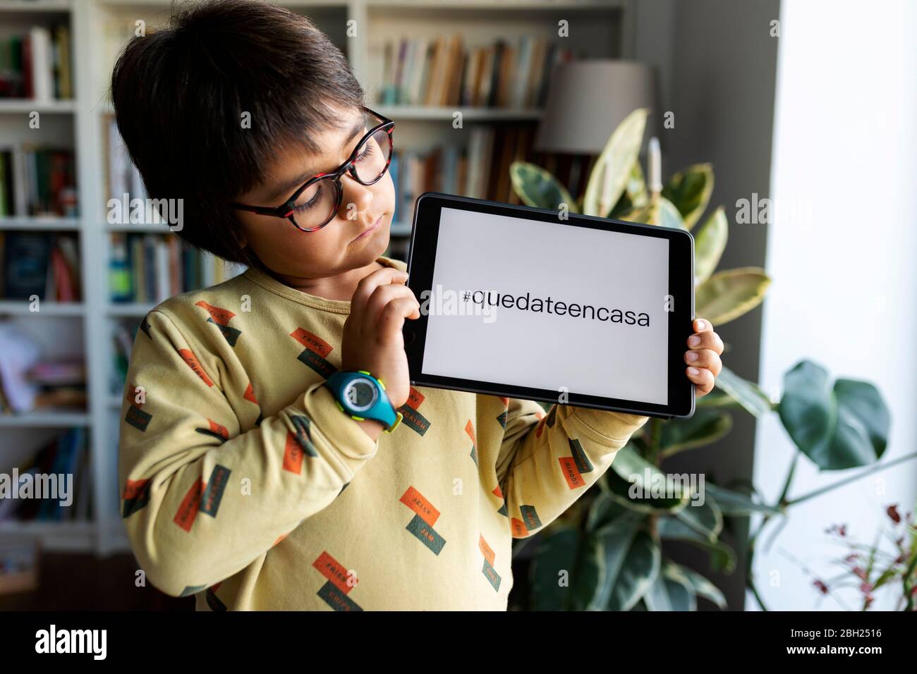 Portrait des kleinen Jungen präsentiert digitale Tablette mit Anfrage Stockfoto
