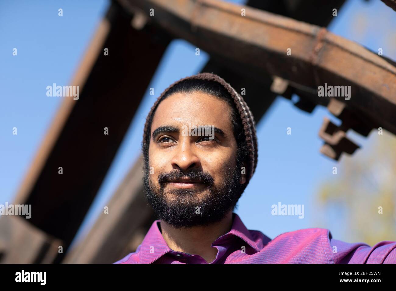 Junger lächelnder Mann, der in die Ferne blickt Stockfoto