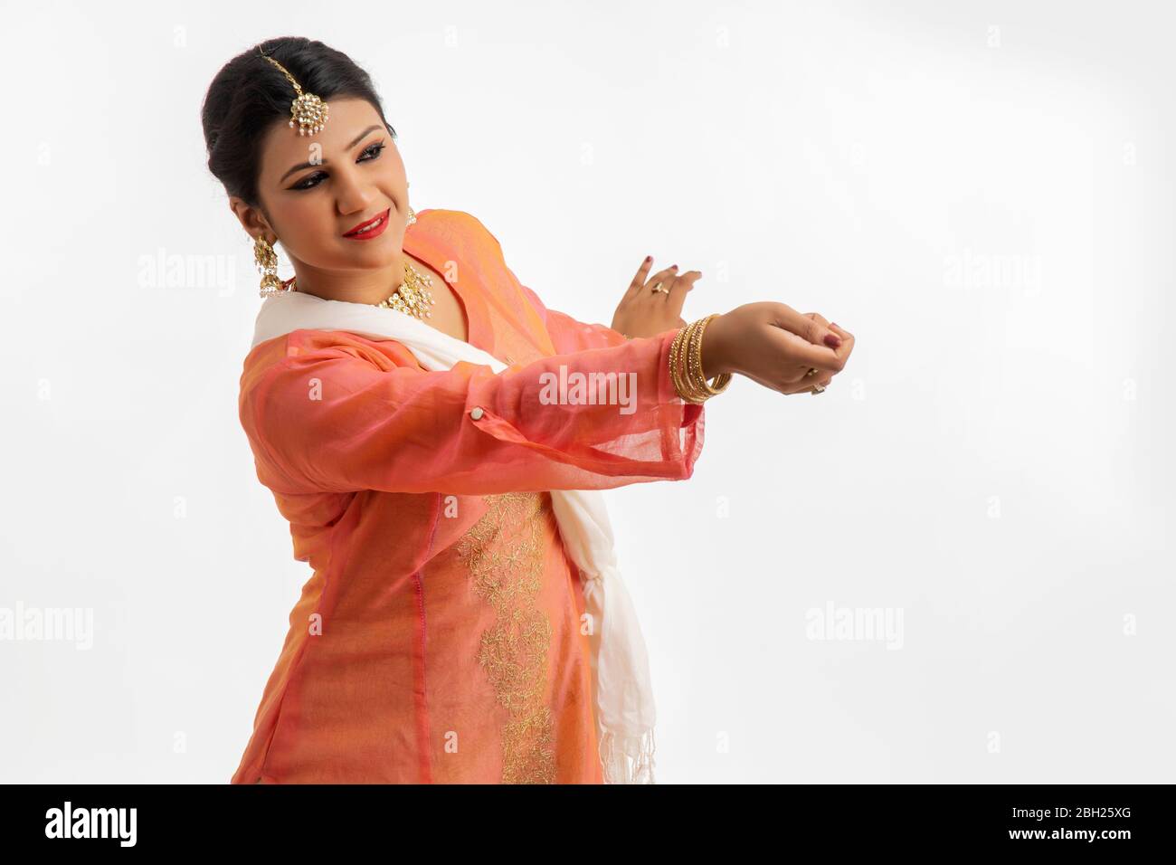 Anmutige Kathak Tänzerin, die auf weißem Hintergrund spielt. Stockfoto