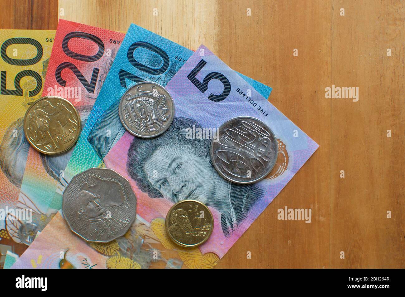 Nahaufnahme eines Bildes australischer Banknoten und Münzen auf einem Holztisch. Währung und Geld aus Australien Stockfoto