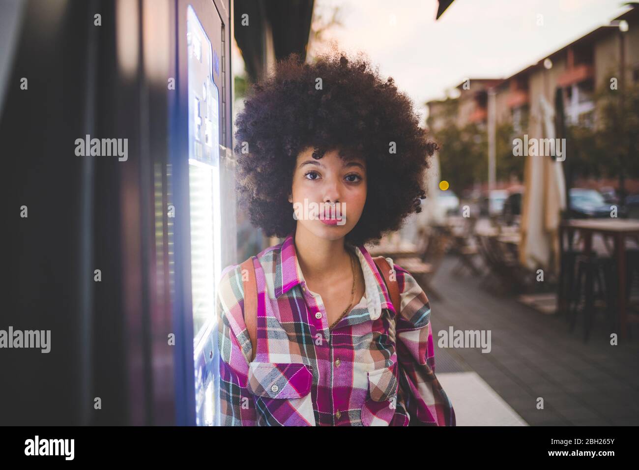 Porträt einer jungen Frau mit Afro-Frisur in der Stadt in der Dämmerung Stockfoto