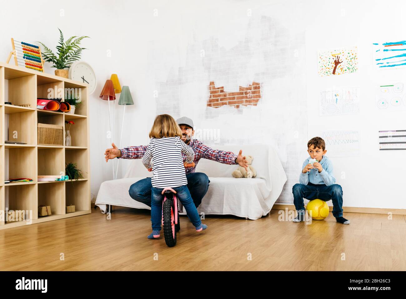 Vater, Tochter und Sohn spielen im Spielzimmer und genießen Freizeit Stockfoto