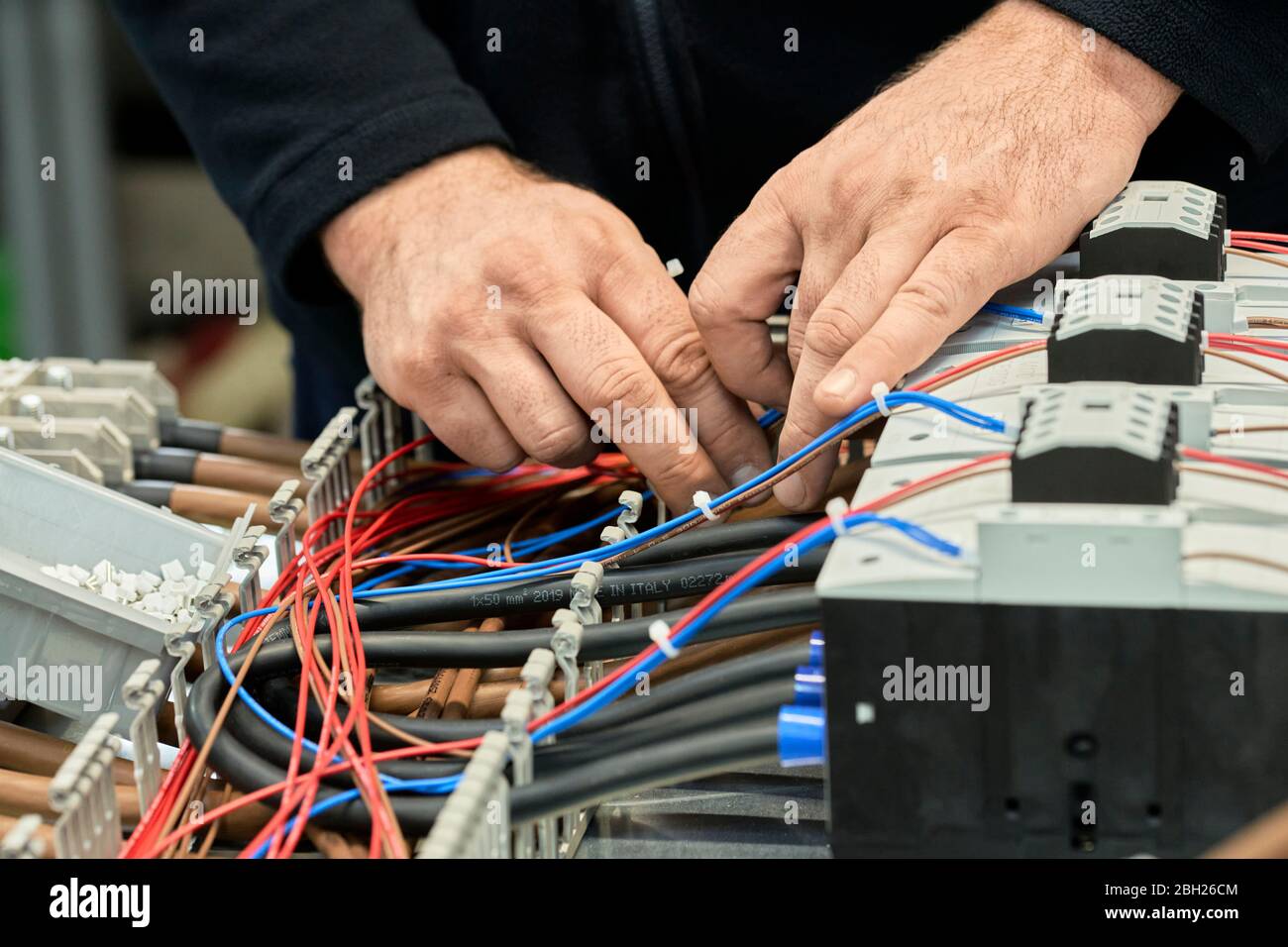 Nahaufnahme des Elektrikers, der an Schaltkreisen arbeitet Stockfoto