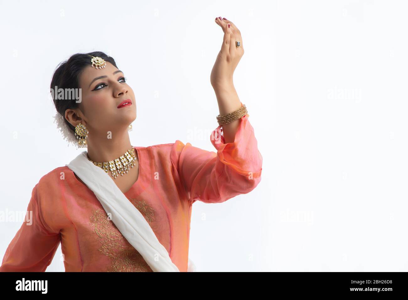 Anmutige Kathak Tänzerin, die auf weißem Hintergrund spielt. Stockfoto