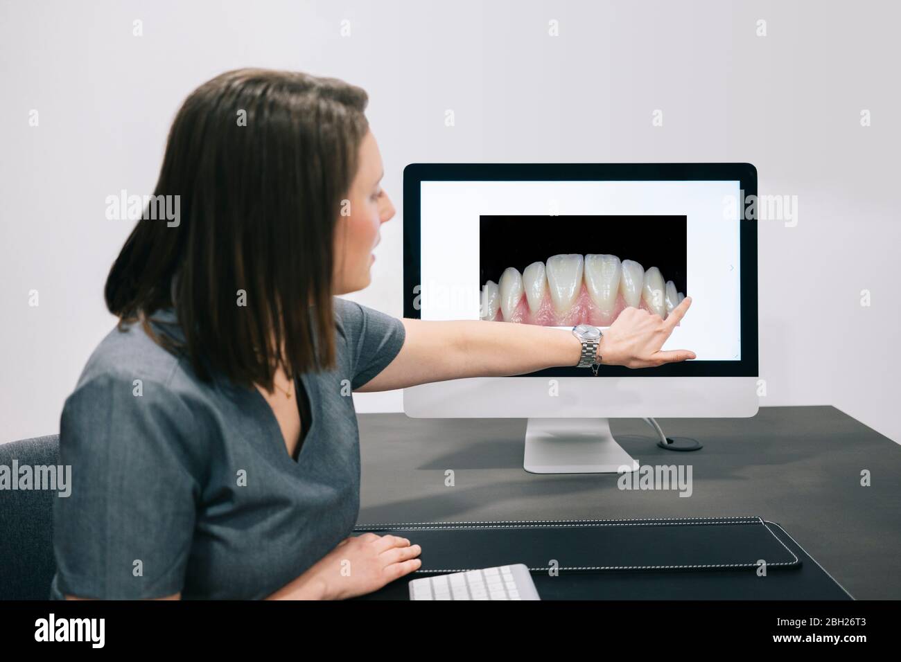 Zahnarzt zeigt auf inage der Zähne auf dem Bildschirm im Büro Stockfoto