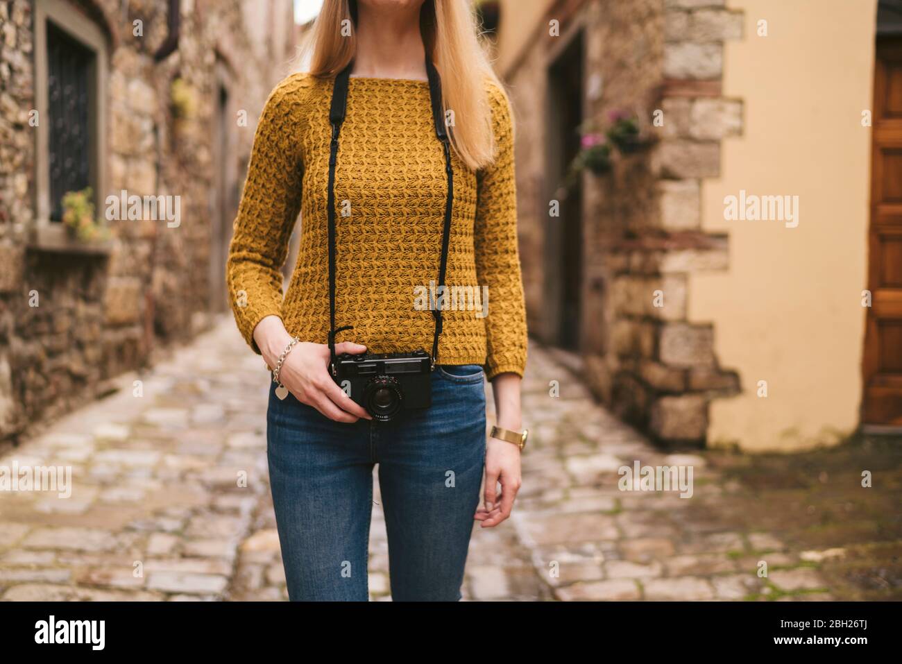 Mittelteil der jungen Frau mit altmodischer Kamera in der Altstadt, Greve in Chianti, Toskana, Italien Stockfoto