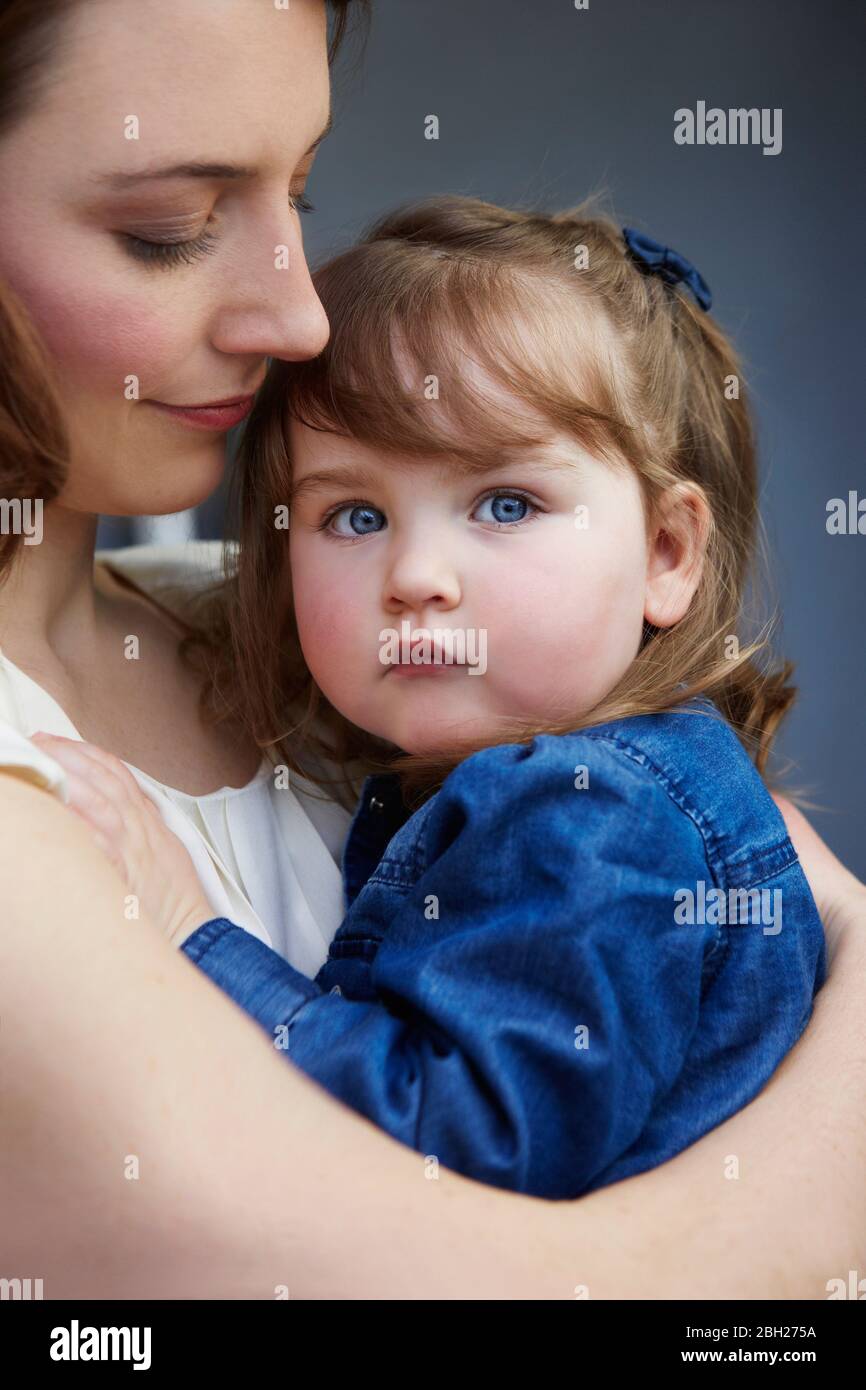Porträt von Kleinkind Mädchen in den Armen ihrer Mutter Stockfoto