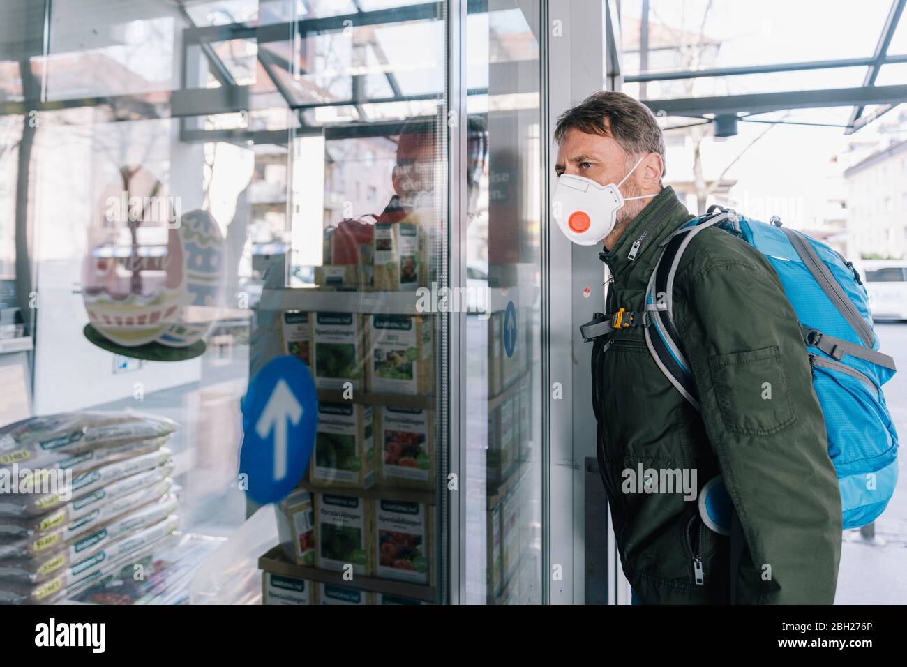 Mann mit Maske, der in den Supermarkt schaut Stockfoto