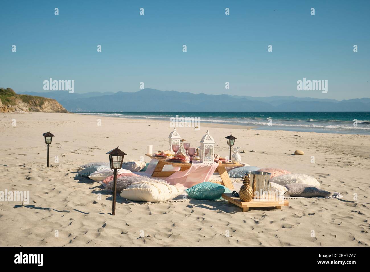 Setzen Sie auf Esstisch am Strand gegen klaren blauen Himmel während sonnigen Tag, Nayarit, Mexiko Stockfoto