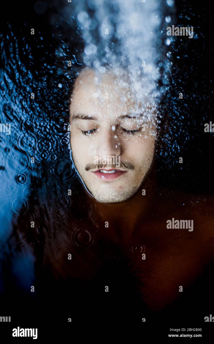 Porträt eines jungen Mannes mit geschlossenen Augen im Wasser Stockfoto