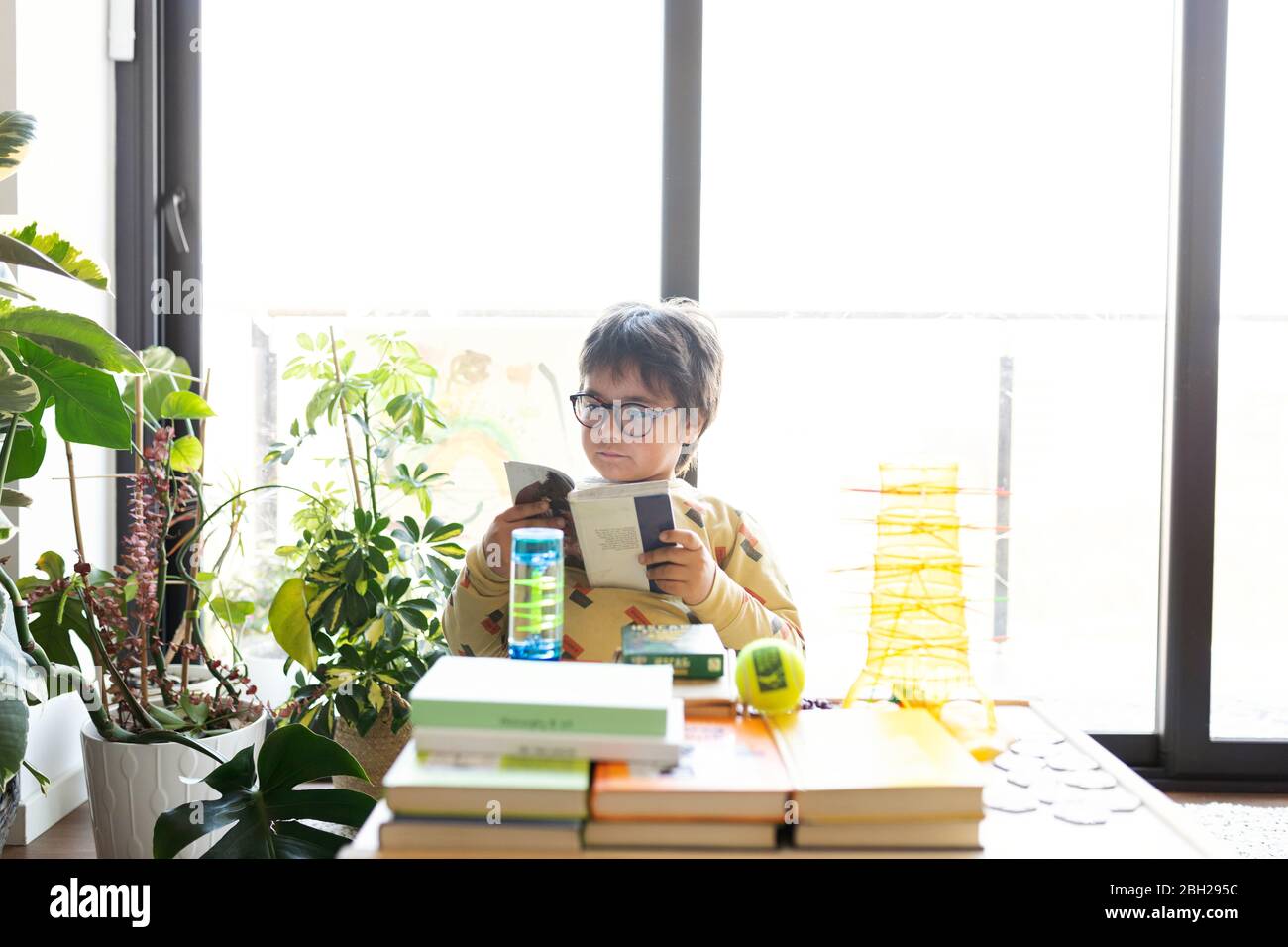 Portrait des kleinen Jungen beim Comic-Lesen zu Hause Stockfoto