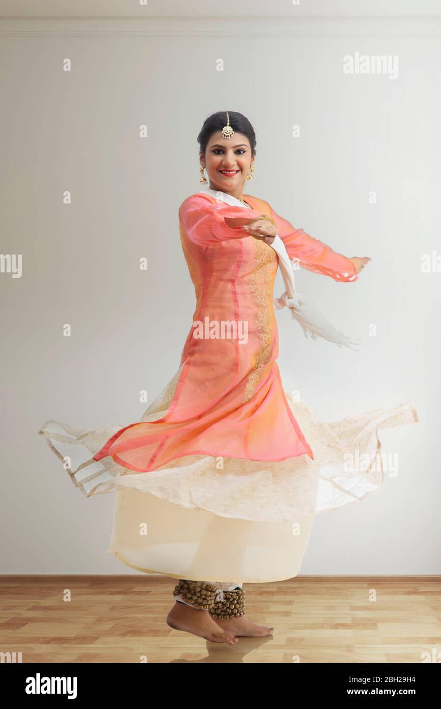 Schöne Kathak Tänzerin kreist und lächelt. Stockfoto