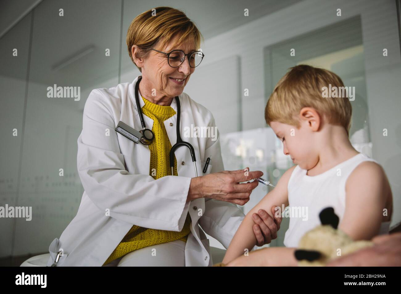 Kinderarzt injiziert Impfstoff in den Arm des Kleinkindes Stockfoto