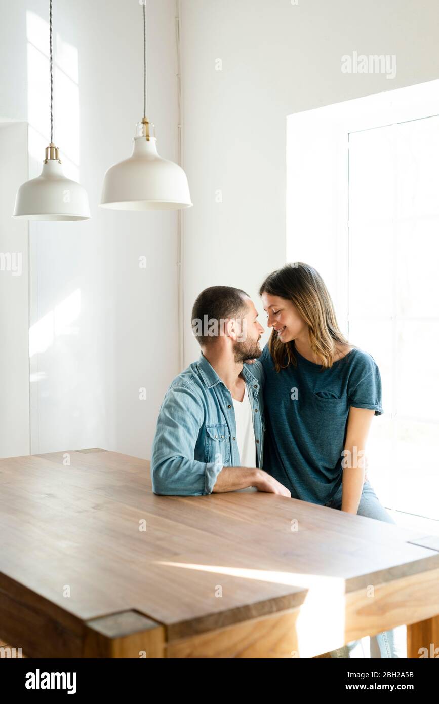 Liebevolles Paar in der Liebe zu Hause entspannen und am Tisch sitzen Stockfoto