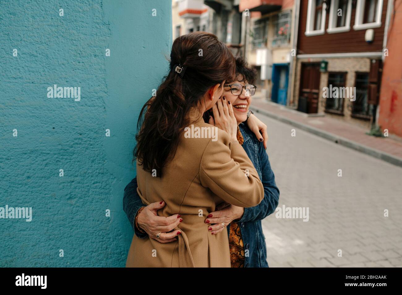 Mutter und Erwachsene Tochter stehen an der Ecke auf der Straße nahe beieinander Stockfoto