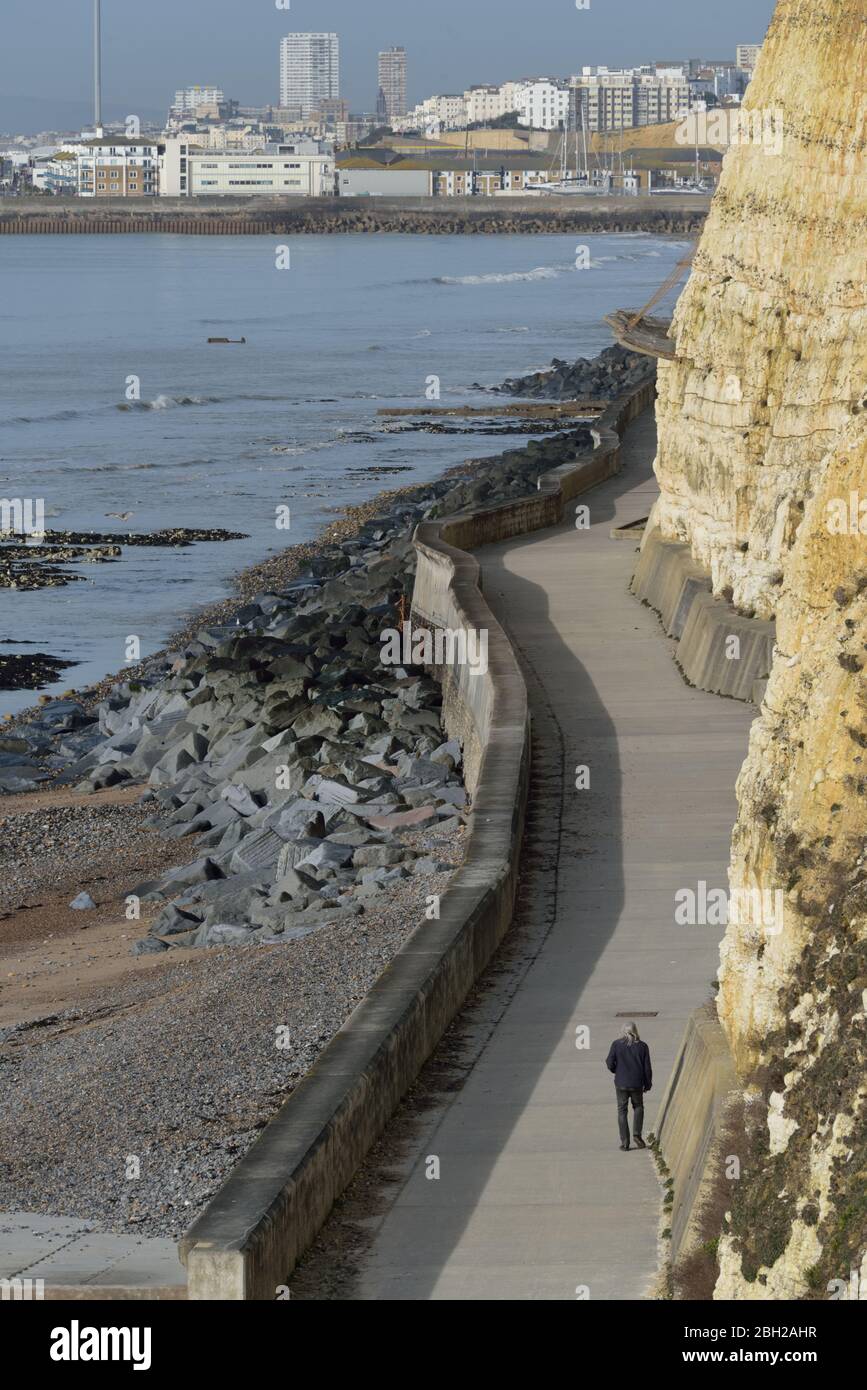 Ein Mann, der am untercliff Walk in Ovingdean entlang läuft, Brighton in der Ferne Stockfoto