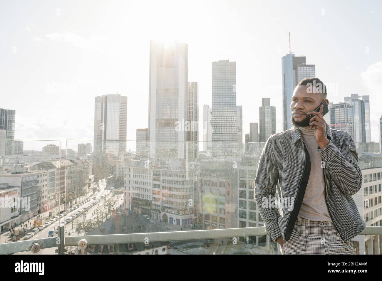 Stilvoller Mann am Telefon auf Aussichtsterrasse mit skycraper-Blick, Frankfurt, Deutschland Stockfoto