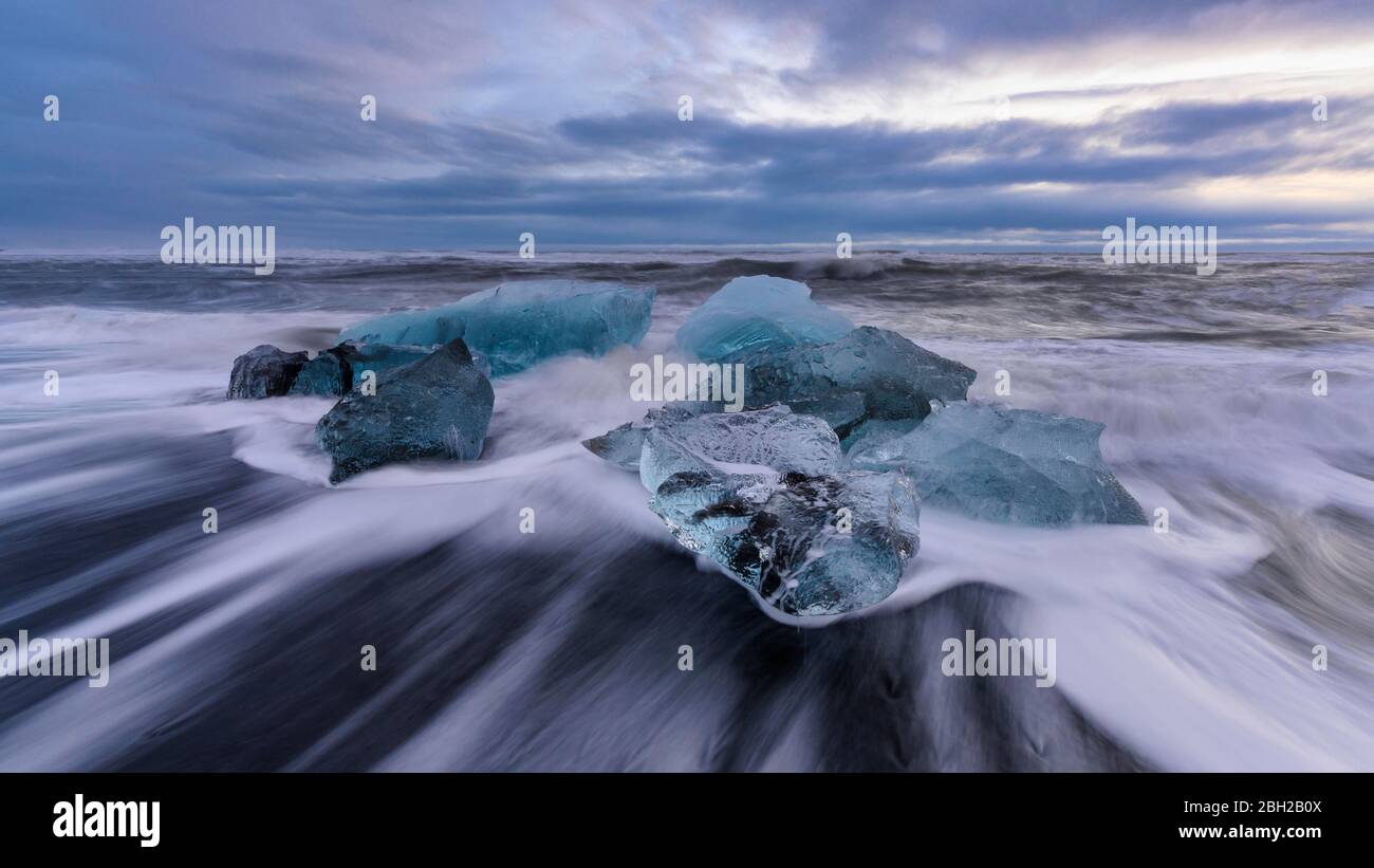Island, Eisbrocken liegen am Ufer von Jokulsarlon in der Dämmerung Stockfoto