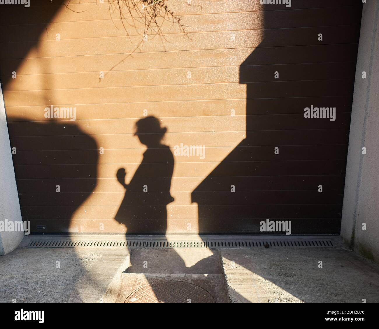 Schatten der jungen Frau spiegelte sich an der Wand im warmen Sommerlicht Stockfoto