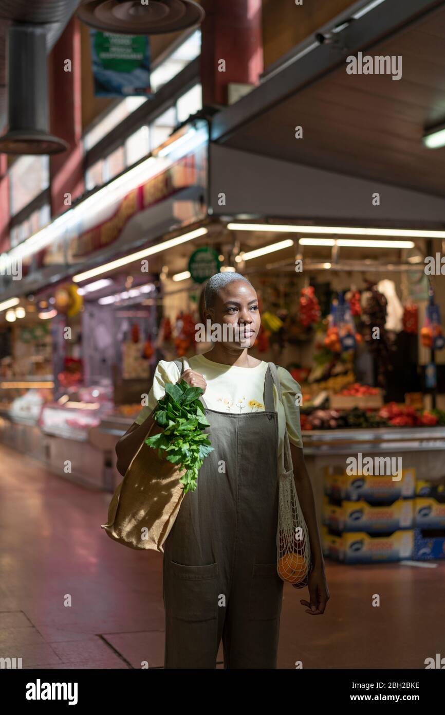 Frau kauft Lebensmittel in einer Markthalle Stockfoto