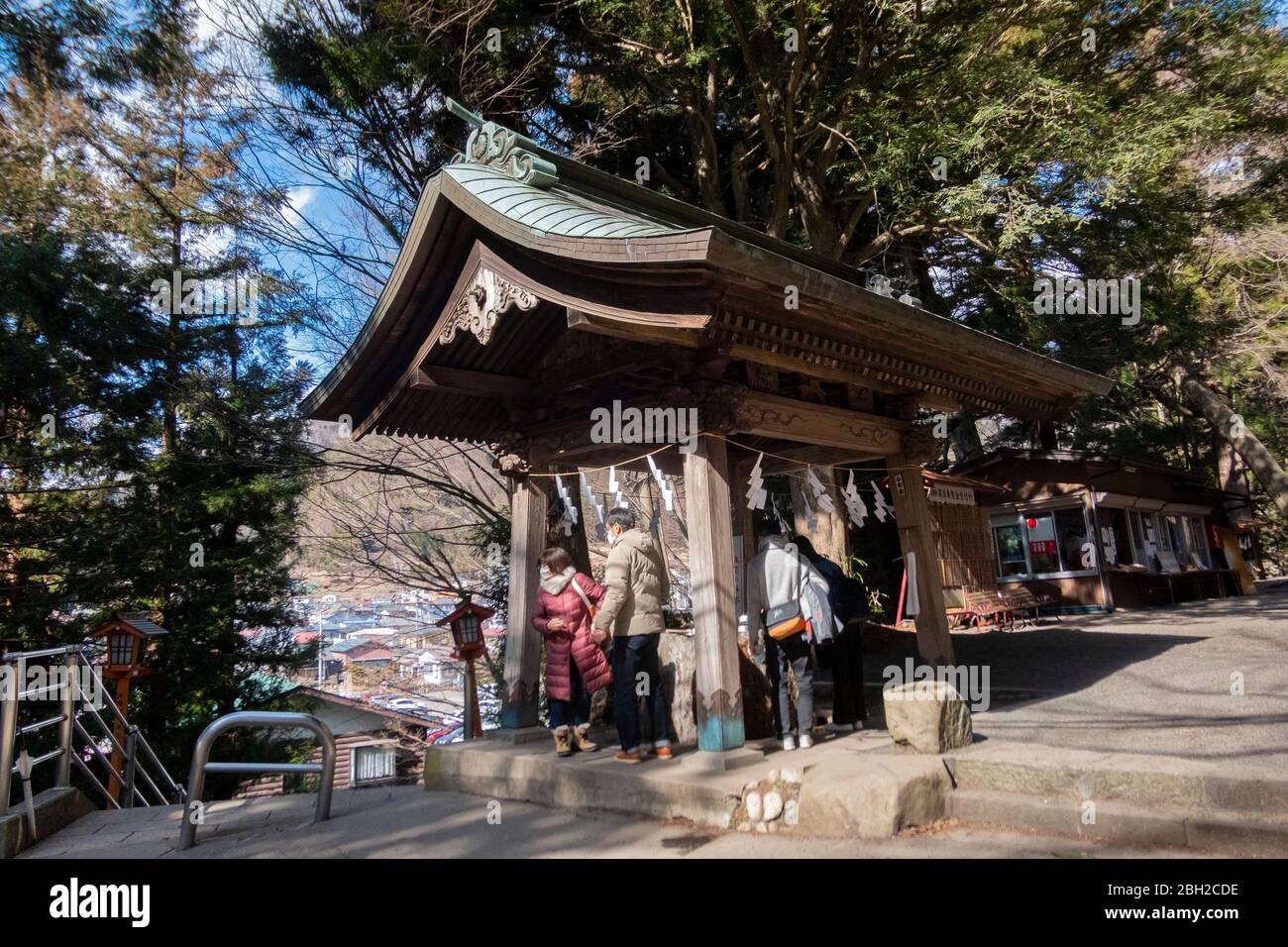 Der Heilige Brunnen auf dem Weg nach Chureito Pagode mit vielen Besuchern unter den Kirschbäumen. Yamanashi, Japan Februar 10,2020 Stockfoto