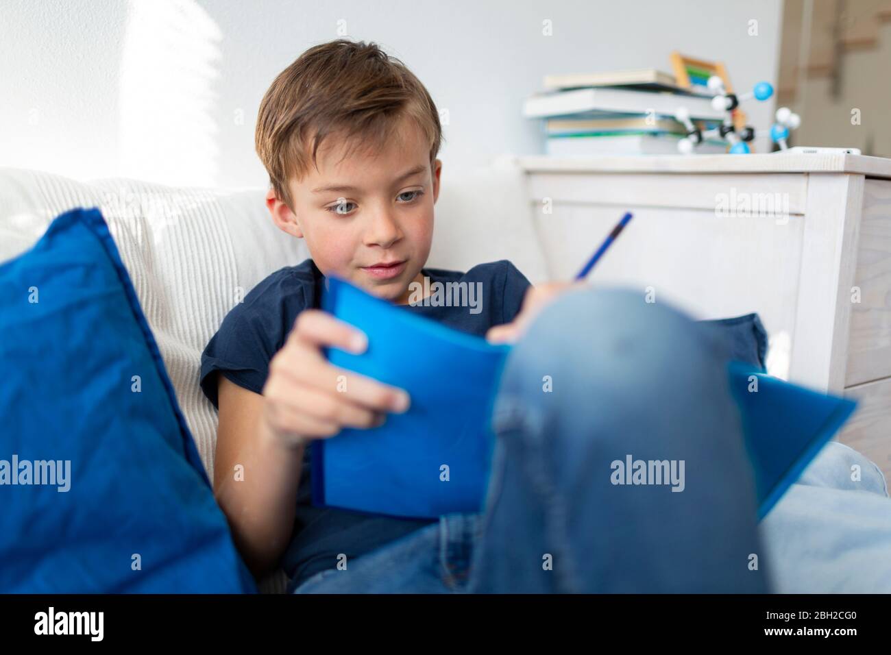 Junge macht Hausaufgaben zu Hause während der Corona-Krise Stockfoto