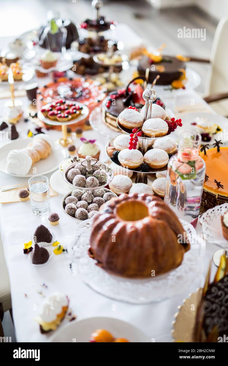 Esstisch mit allen Arten von Snacks und Desserts gefüllt Stockfoto