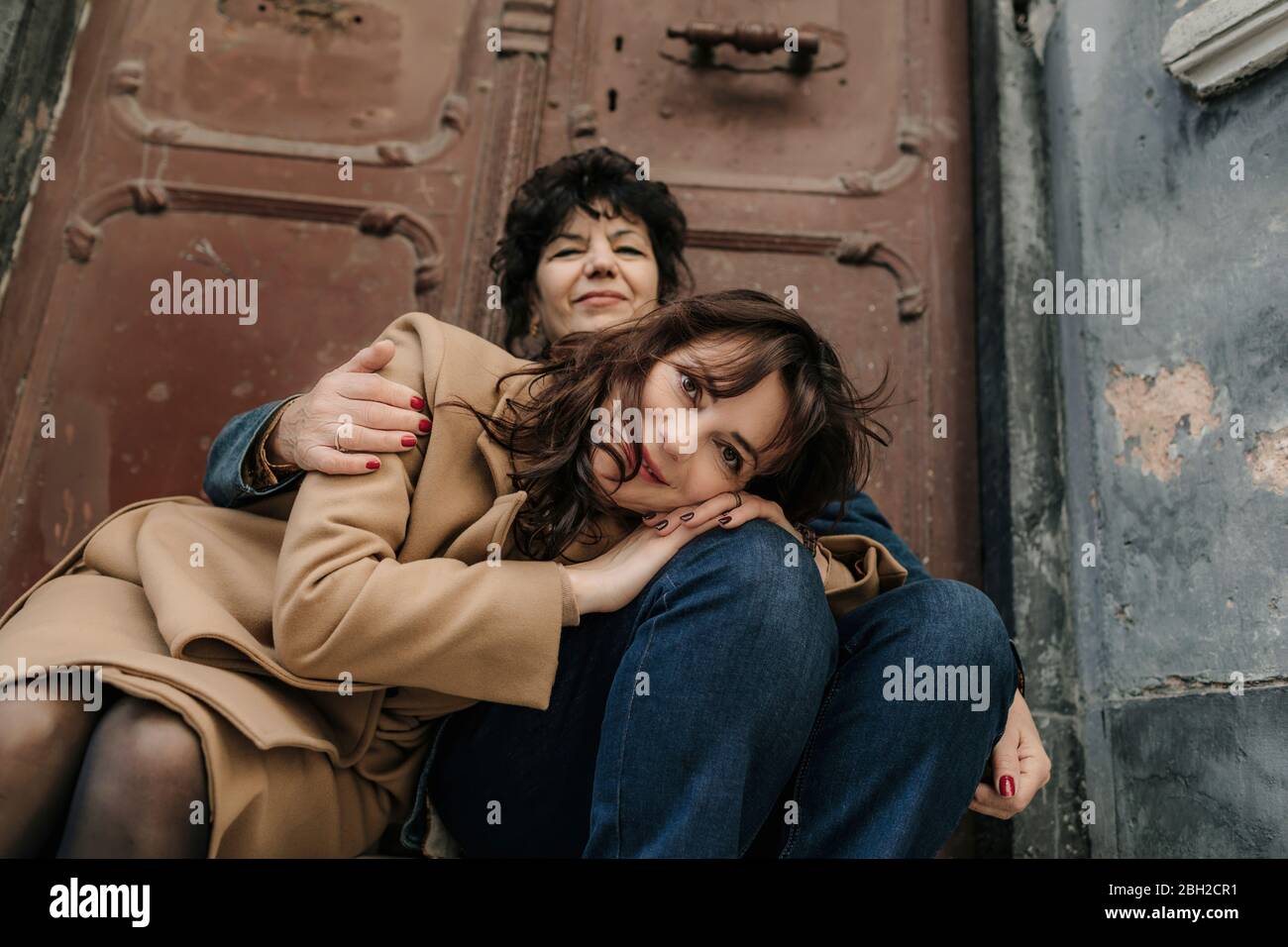 Porträt einer glücklichen Frau, die sich im Freien neben ihren lächelnden Müttern befindet Stockfoto