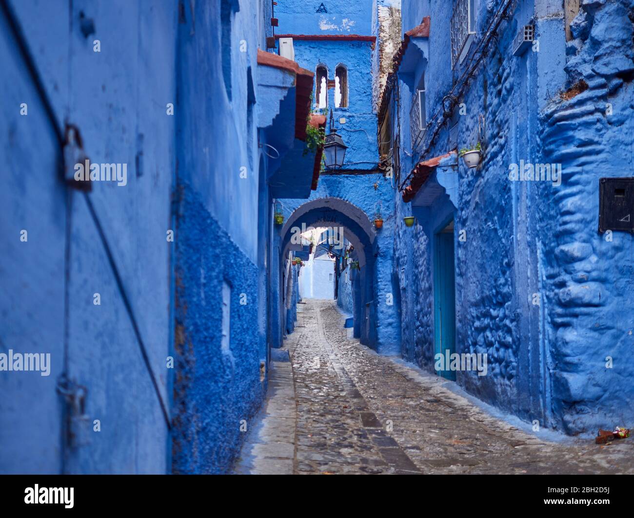 Marokko, Chefchaouen Provinz, Chefchaouen, Bogen von leerem Kopfsteinpflaster Gasse zwischen alten blauen Häusern Stockfoto