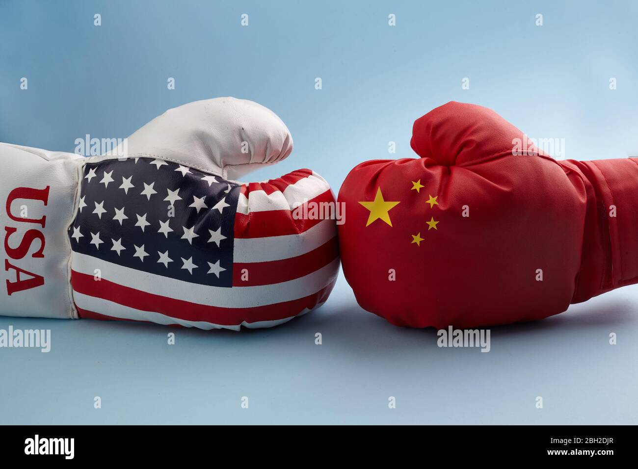 Konzept des Handelskrieges zwischen den USA und China. Zwei Hände mit Boxhandschuhen mit China- und USA-Flagge. Stockfoto