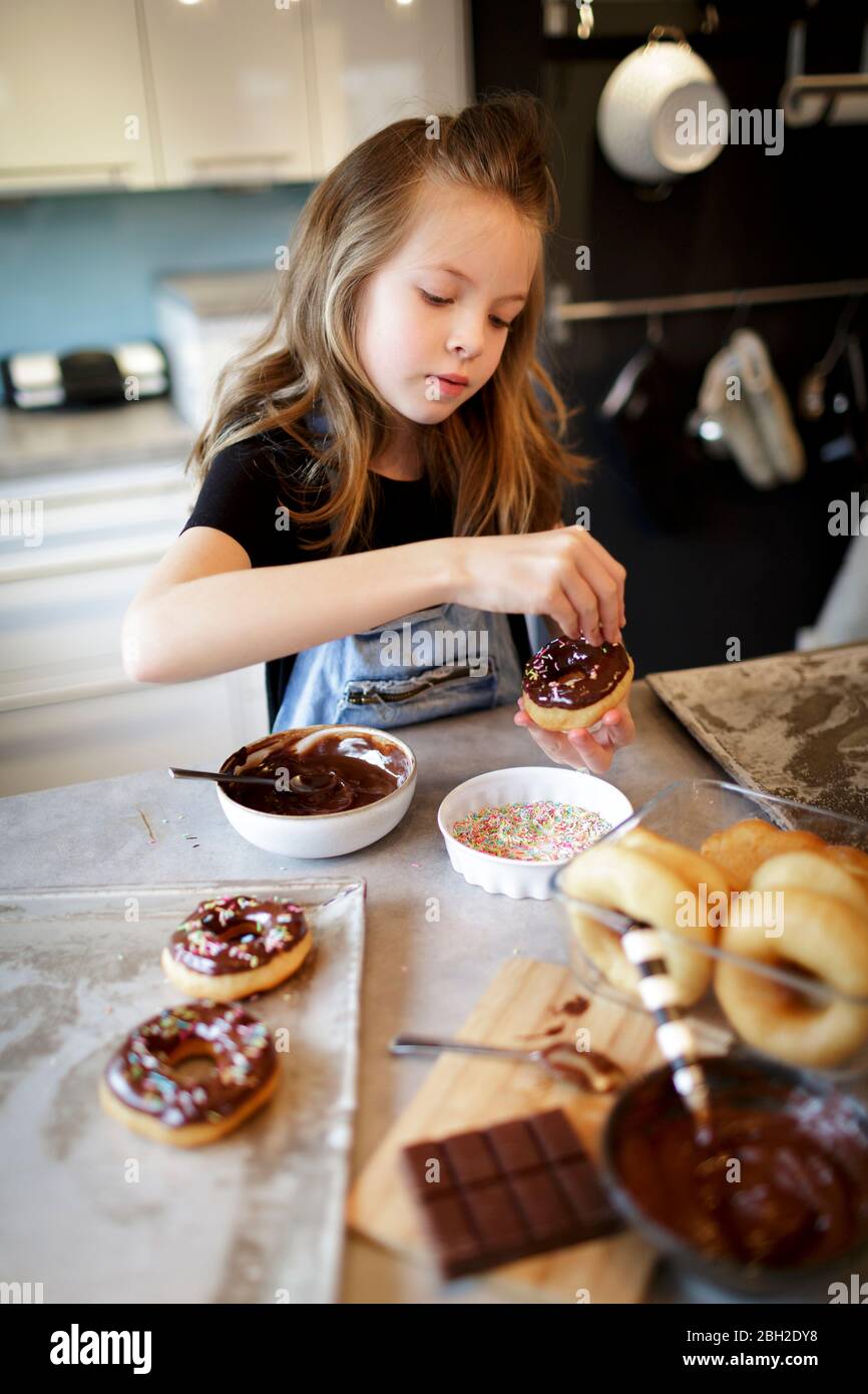 Portrait of girl Dekoration hausgemachte Donuts mit Zucker Granulat Stockfoto