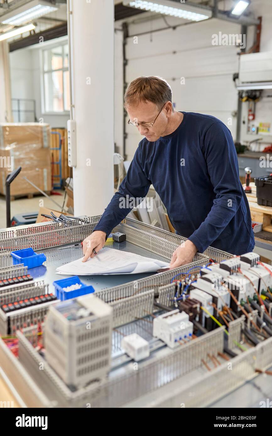 Elektriker prüft Schaltkreise in der Werkstatt Stockfoto