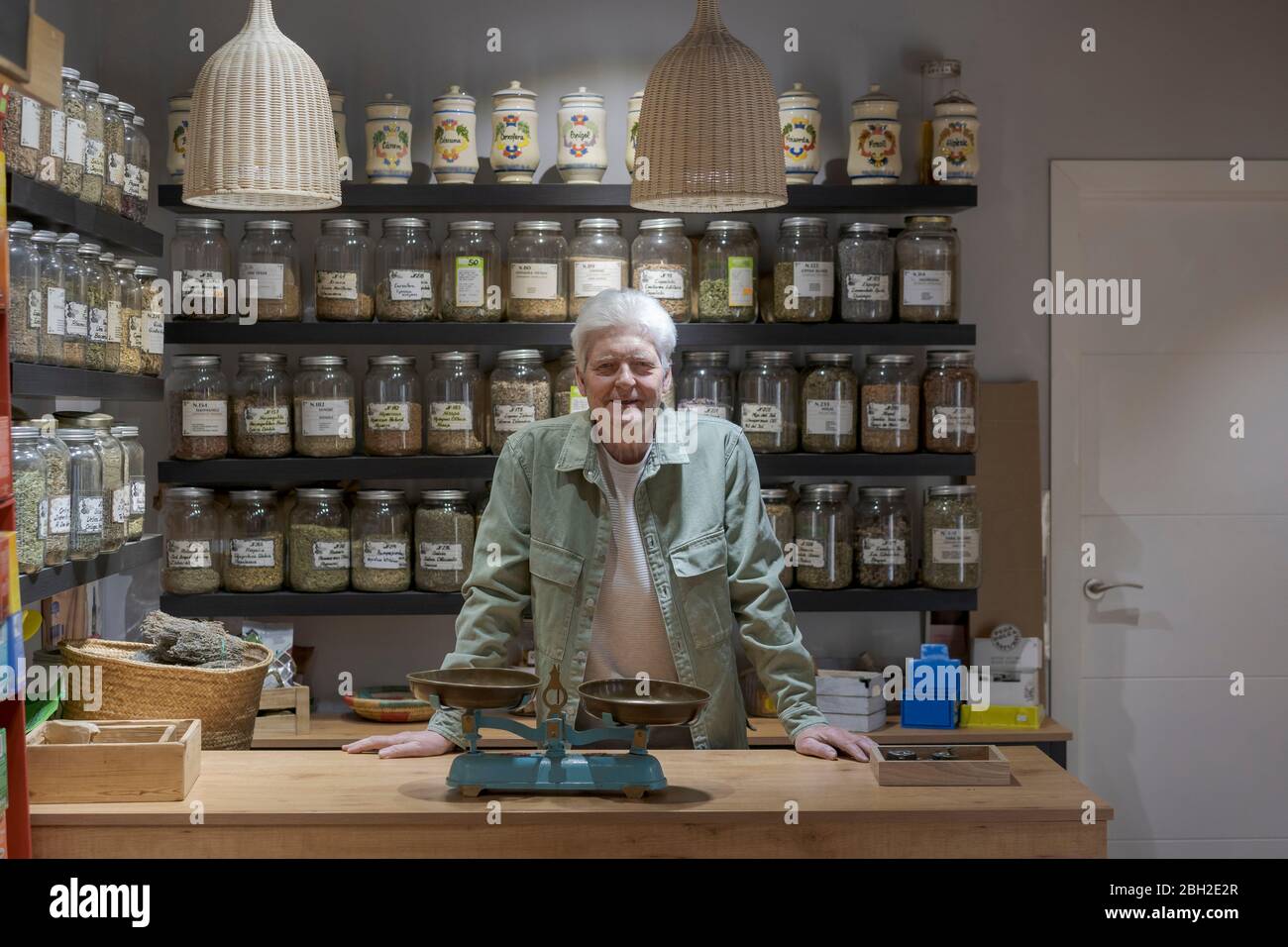 Porträt eines selbstbewussten älteren Mannes hinter der Theke in seinem Geschäft Stockfoto