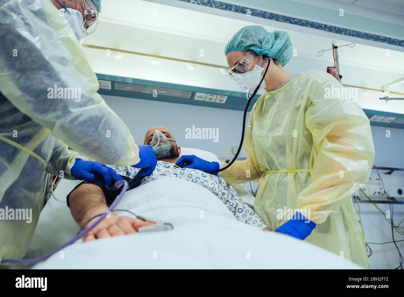 Ärzte, die den Patienten in der Notaufnahme eines Krankenhauses mit Atemgeräten versorgen Stockfoto