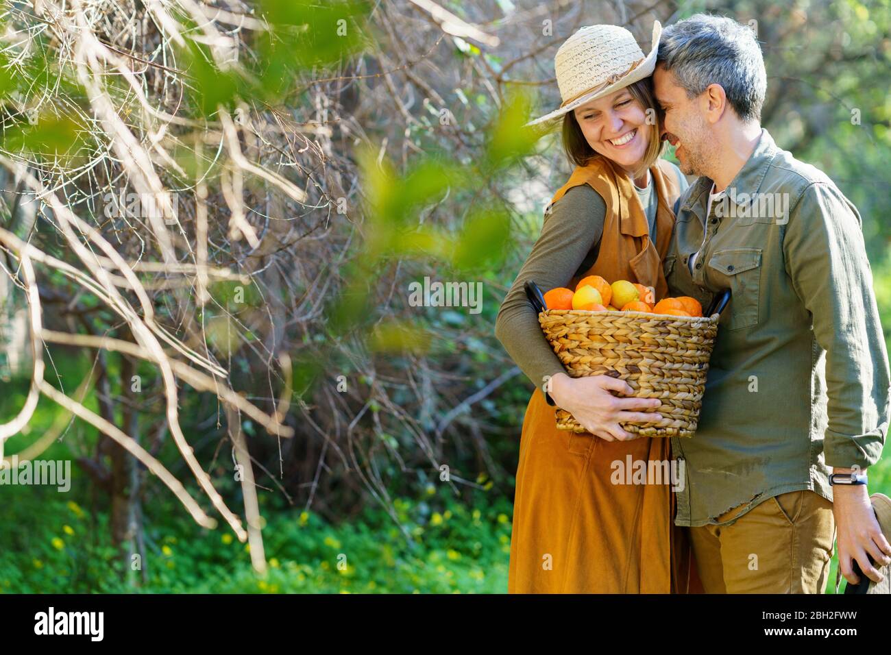 Hapy paar mit Korb voller Orangen auf dem Feld Stockfoto