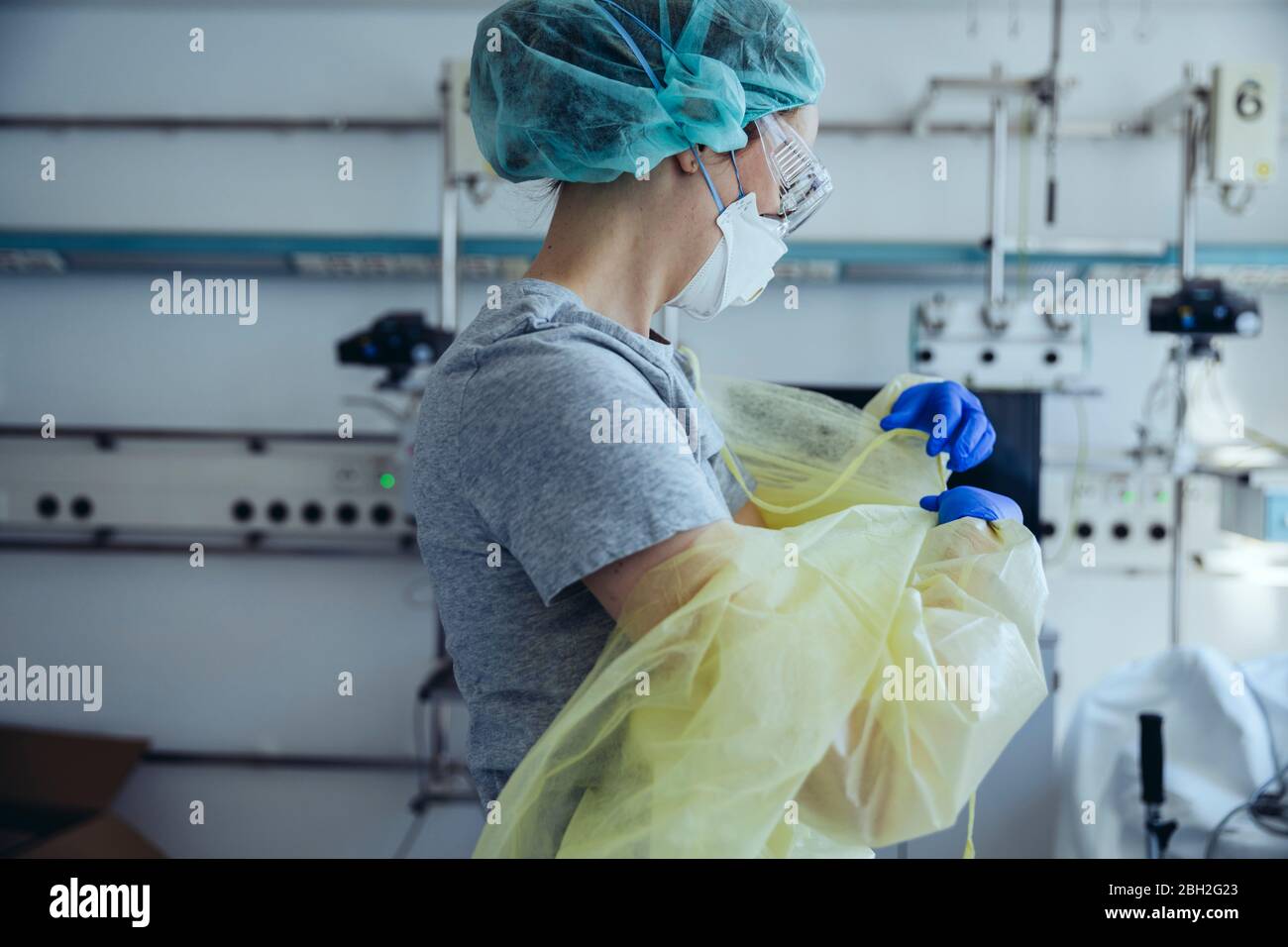Arzt, der persönliche Schutzausrüstung im Krankenhaus abnimmt Stockfoto