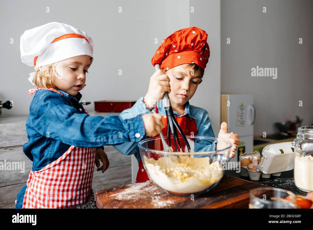 Bruder und Schwester bereiten Teig in der Küche zu Hause Stockfoto