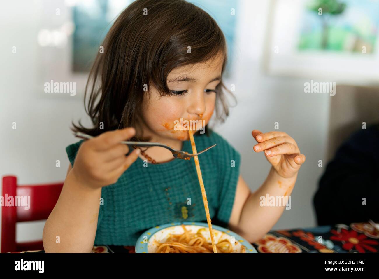 Portrait von kleinen Mädchen mit verschmiertem Gesicht essen Pasta Stockfoto