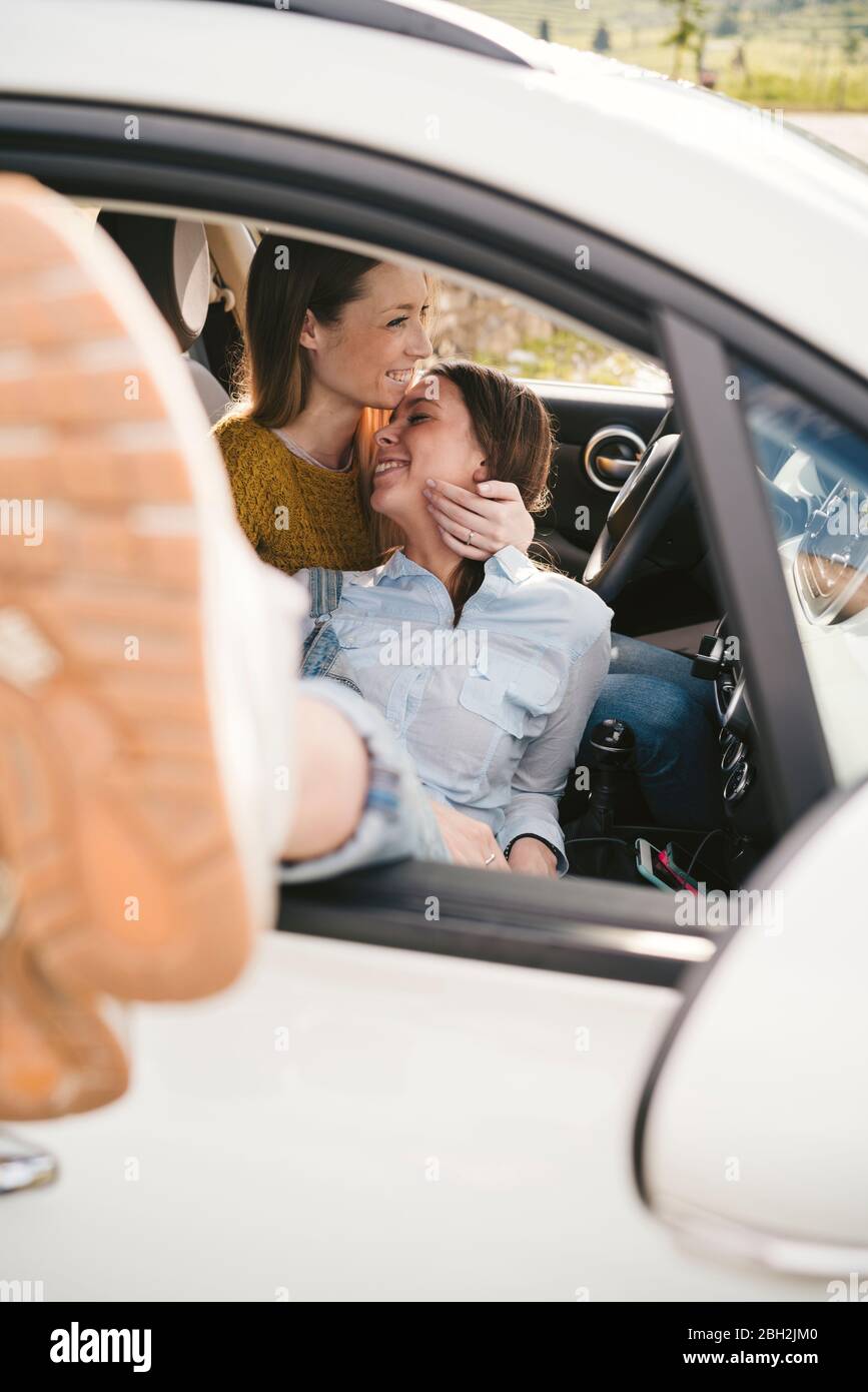 Zwei glückliche, liebevolle junge Frauen in einem Auto Stockfoto