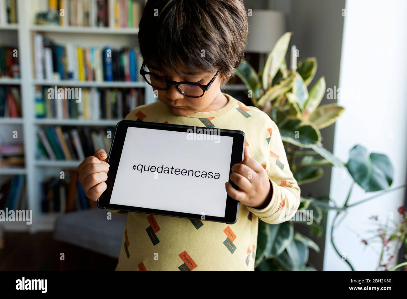 Kleiner Junge präsentiert digitale Tablet mit Anfrage Stockfoto