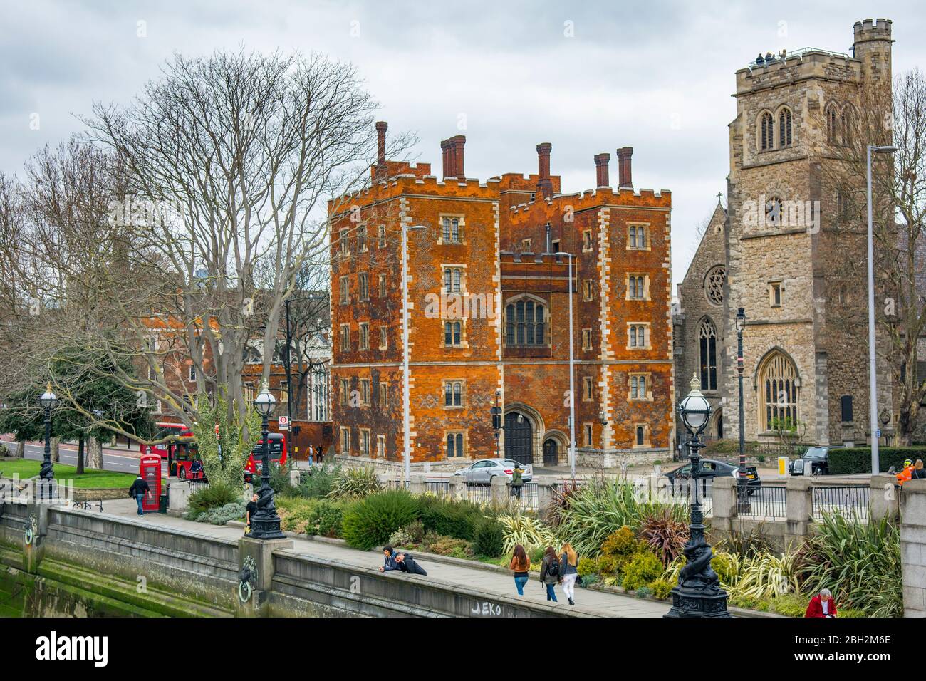 LONDON - Blick auf Lambeth Palace und Menschen, die von der Lambeth Bridge an der Themse entlang spazieren Stockfoto