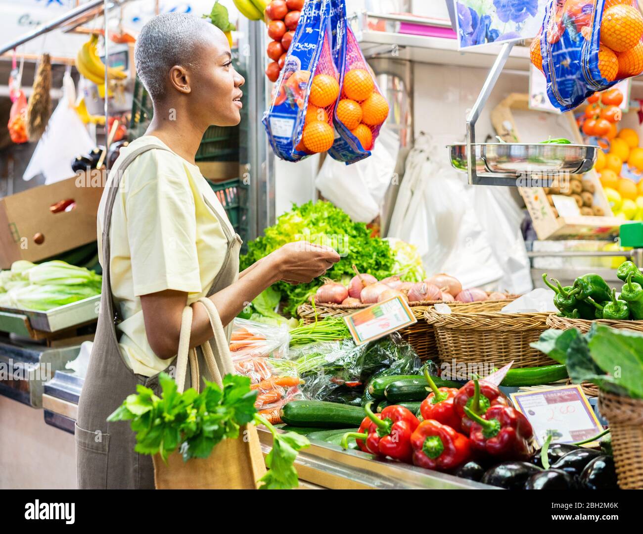 Frau kauft Lebensmittel in einer Markthalle Stockfoto