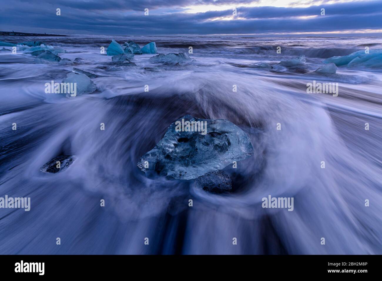 Island, Eisbrocken liegen am Ufer von Jokulsarlon in der Dämmerung Stockfoto