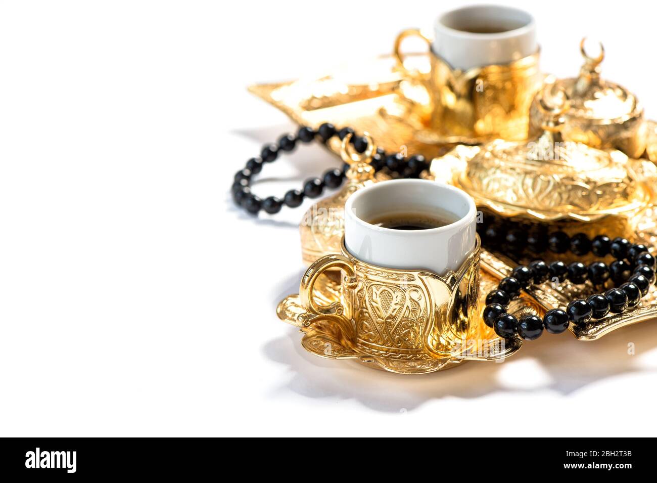 Goldene Kaffeetassen und Rosenkranz Perlen. Islamische Feiertage. Ramadan. Selektiver Fokus Stockfoto